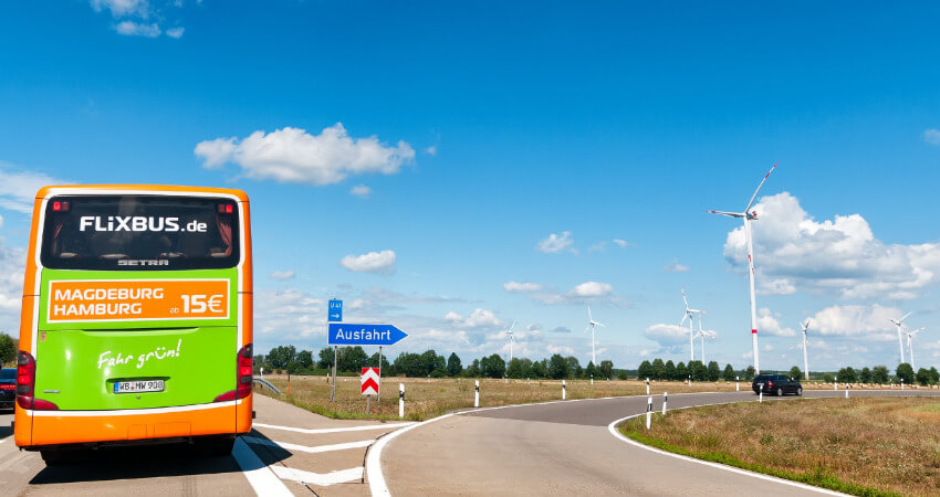 Ein grüner Flixbus fährt auf die Autobahn auf.